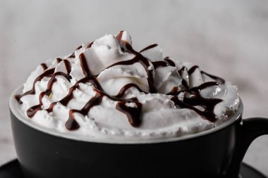 Krem şanti ve çikolata soslu kahve. Karanlık bardakta buzlu frappuccino parlak mermer arka planda izole edilmiş. Genel görünüm, kopyalama alanı. Kafe menüsü reklamı. Kahve dükkanı menüsü. Yatay ph