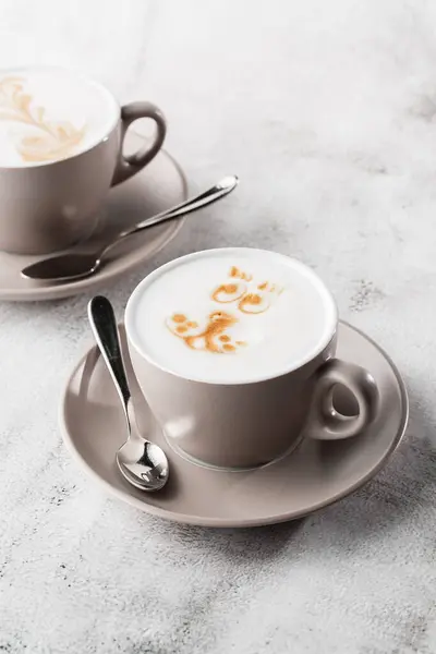 Duas xícaras brancas de café quente com latte de espuma de leite bonito textura arte latte isolado em fundo de mármore brilhante. Visão geral, espaço de cópia. Publicidade para menu de café. Menu da cafetaria. Pho vertical — Fotografia de Stock