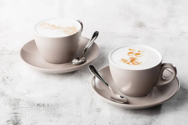 Duas xícaras brancas de café quente com latte de espuma de leite bonito textura arte latte isolado em fundo de mármore brilhante. Visão geral, espaço de cópia. Publicidade para menu de café. Menu da cafetaria. Horizontal p — Fotografia de Stock