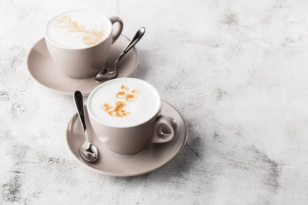 Две белые чашки горячего кофе латте с красивой текстурой латте молока, выделенные на ярком мраморном фоне. Вид сверху, место для копирования. Реклама меню кафе. Меню кафе. Горизонтальная p — стоковое фото