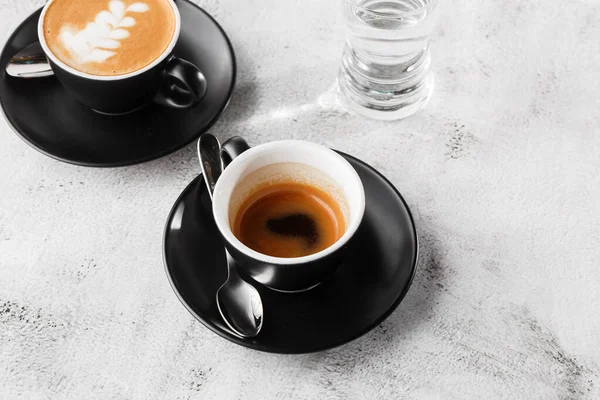 Due tazze scure di caffè nero caldo, espresso, cappuccino con latte isolato su fondo marmo brillante. Vista aerea, copiare spazio. Pubblicità per il menu del caffè. Menù della caffetteria. Foto orizzontale . — Foto Stock