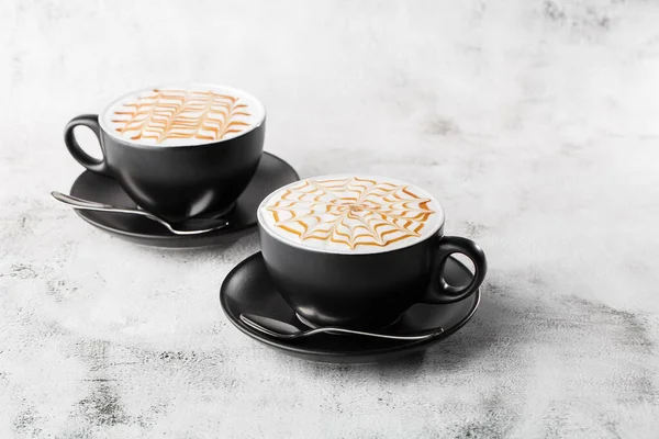 Parlak mermer arka planda izole edilmiş sütlü, karamel latte sanat dokusuyla iki koyu kahve. Genel görünüm, kopyalama alanı. Kafe menüsü reklamı. Kahve dükkanı menüsü. Yatay fotoğraf. — Stok fotoğraf