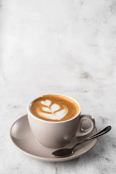 Tazza bianca di caffè latte caldo con bella schiuma di latte latte texture arte isolata su sfondo di marmo luminoso. Vista aerea, copiare spazio. Pubblicità per il menu del caffè. Menù della caffetteria. Foto verticale . — Foto Stock