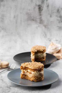 Muz ya da mermer arka planda gri tabakta fındıklı kek. Seçici odaklanma. Dikey fotoğraf. Fırın için menü. Kafe menüsü. Hamur işi. Cafe restoranında lezzetli ve tatlı bir tatlı..