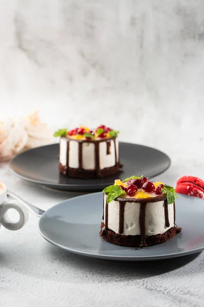 Meyveli mini yuvarlak sufle keki ve mermer arka planda çikolatalı jöle. Pasta kafesi ya da kafe menüsü için duvar kağıdı. dikey.