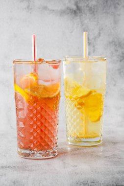 İki bardak limonata ve portakal kokteyli, limon ve portakal, soğuk, ferahlatıcı içecek ya da parlak mermer arka planda buzlu içecek. Genel görünüm, kopyalama alanı. Kafe menüsü reklamı. Dikey