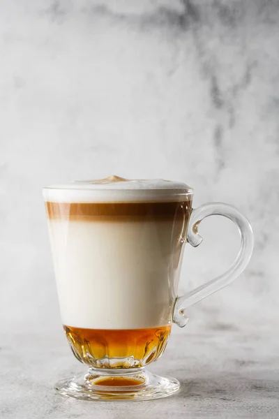 Coffee with Irish whiskey and whipped cream in glass isolated on bright marble background. Overhead view, copy space. Advertising for cafe menu. Coffee shop menu. Vertical photo.