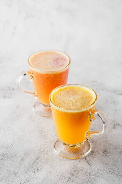 Dua gelas jus buah jeruk segar diisolasi pada latar belakang marmer terang. Pandangan ke atas, salin ruang. Iklan untuk menu kafe. Foto vertikal . — Stok Foto