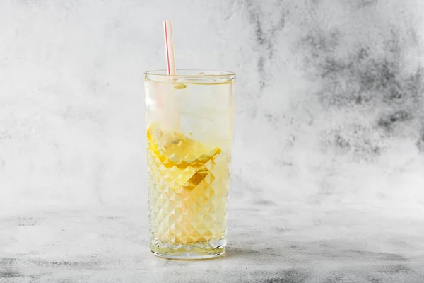 Glass with lemonade with lemon, cold refreshing drink or beverage with ice on bright marble background. Overhead view, copy space. Advertising for cafe menu. Horizontal photo. — Stock Photo, Image