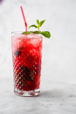 Limon ve nane aromalı çilekli mojito kokteyli, soğuk ferahlatıcı içecek ya da parlak mermer arka planda buzlu içecek. Genel görünüm, kopyalama alanı. Kafe menüsü reklamı. Dikey fotoğraf.