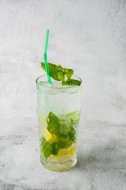Limon ve naneli klasik mojito kokteyli, soğuk ferahlatıcı içecek ya da parlak mermer arka planda buzlu içecek. Genel görünüm, kopyalama alanı. Kafe menüsü reklamı. Dikey fotoğraf.