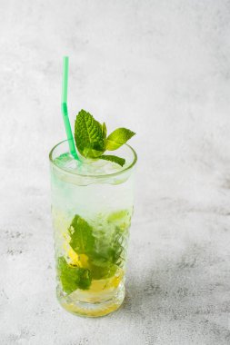 Limon ve naneli klasik mojito kokteyli, soğuk ferahlatıcı içecek ya da parlak mermer arka planda buzlu içecek. Genel görünüm, kopyalama alanı. Kafe menüsü reklamı. Dikey fotoğraf.