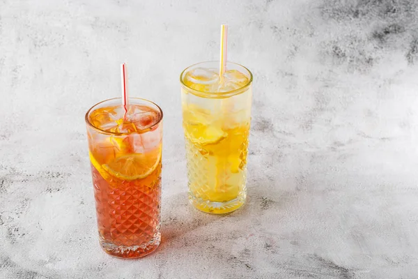 Dua gelas dengan limun dan jeruk koktail dengan lemon dan oranye, minuman menyegarkan dingin atau minuman dengan es di latar marmer terang. Pandangan ke atas, salin ruang. Iklan untuk menu kafe. Horizon — Stok Foto