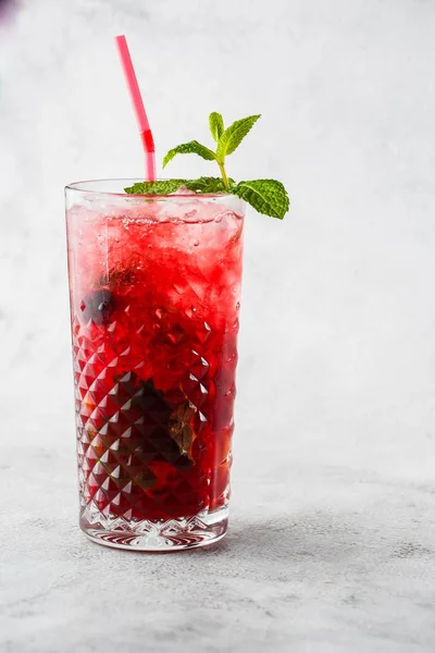 Limon ve nane aromalı çilekli mojito kokteyli, soğuk ferahlatıcı içecek ya da parlak mermer arka planda buzlu içecek. Genel görünüm, kopyalama alanı. Kafe menüsü reklamı. Dikey fotoğraf.