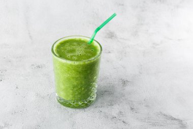 Sağlıklı bir yaşam tarzı ıspanak, yeşil elma, salatalık ve parlak mermer zeminde izole edilmiş yulaf ezmesi için meyve ve sebzelerden taze yeşil smoothie. Genel görünüm, kopyalama alanı. Kafe adamları için reklam.