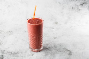Berry smoothie ya da ahududu pembesi, parlak mermer arka planda kırmızı milkshake. Genel görünüm, kopyalama alanı. Milkshake kafe menüsü reklamı. Kahve dükkanı menüsü. Yatay fotoğraf.