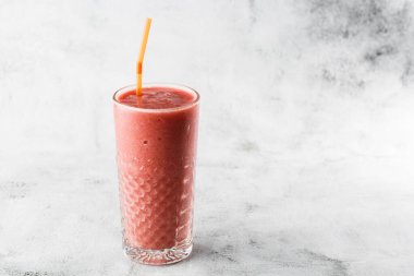 Berry smoothie ya da ahududu pembesi, parlak mermer arka planda kırmızı milkshake. Genel görünüm, kopyalama alanı. Milkshake kafe menüsü reklamı. Kahve dükkanı menüsü. Yatay fotoğraf.