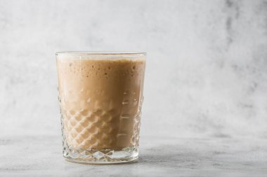Parlak mermer zemin üzerinde soğuk kahve ve süt ile izole edilmiş bir bardak. Genel görünüm, kopyalama alanı. Kafe menüsü reklamı. Kahve dükkanı menüsü. Yatay fotoğraf.