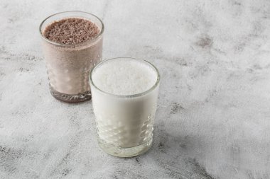 İki bardak buzlu kakao ya da parlak mermer arka planda izole edilmiş çikolatalı süt. Genel görünüm, kopyalama alanı. Kafe menüsü reklamı. Kahve dükkanı menüsü. Yatay fotoğraf.