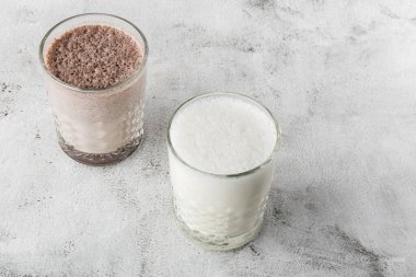 İki bardak buzlu kakao ya da parlak mermer arka planda izole edilmiş çikolatalı süt. Genel görünüm, kopyalama alanı. Kafe menüsü reklamı. Kahve dükkanı menüsü. Yatay fotoğraf.