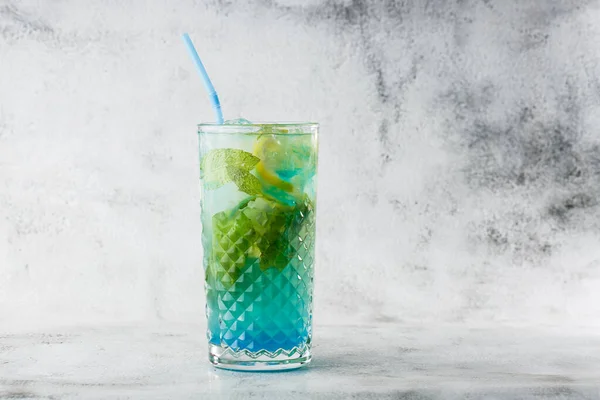 Blue cocktail with ice cubes and slices of lemon and lime. Blue lagoon summer coctail. Iced blue lemonade. Overhead view, copy space. Advertising for cafe. Bar menu. Horizontal photo. — Stock Photo, Image