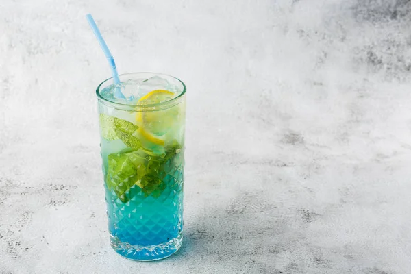 Blauer Cocktail mit Eiswürfeln und Zitronen- und Limettenscheiben. Sommercoctail aus der blauen Lagune. eisblaue Limonade. Overhead-Ansicht, Kopierraum. Werbung für Cafés. Bar-Menü. Horizontales Foto. — Stockfoto