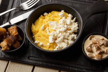 Tipik Ukrayna çanak polenta - peynir ve domuz yağı ile Banosh. Ukrayna mutfağı. pastırma ile mısır lapası, çatırtıve ahşap arka plan tabakta peynir Mısır lapası.