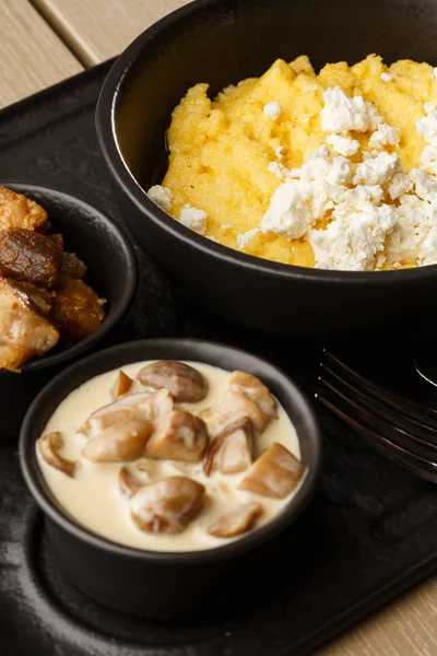 Tipik Ukrayna çanak polenta - peynir ve domuz yağı ile Banosh. Ukrayna mutfağı. pastırma ile mısır lapası, çatırtıve ahşap arka plan tabakta peynir Mısır lapası. — Stok fotoğraf