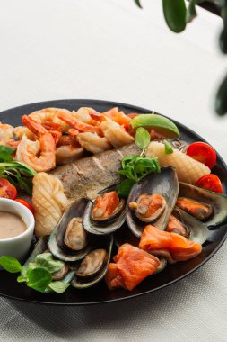 Kızarmış karışık deniz ürünleri midye, karides, somon, kalamar mürekkep balığı ve baharatlı acılı balık sarımsağı. Beyaz Arka plan 'da izole edilmiş. Deniz ürünleri ve et tabağı. Akdeniz c