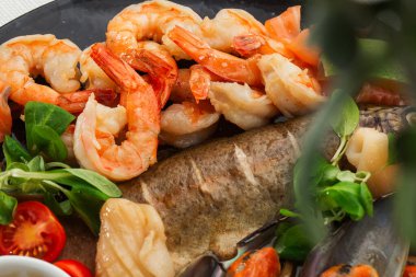 Kızarmış karışık deniz ürünleri midye, karides, somon, kalamar mürekkep balığı ve baharatlı acılı balık sarımsağı. Beyaz Arka plan 'da izole edilmiş. Deniz ürünleri ve et tabağı. Akdeniz c