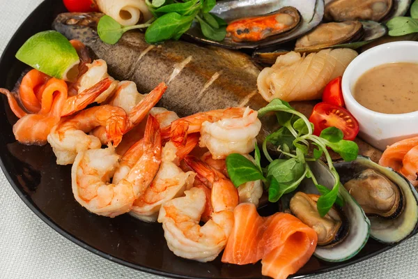 Roasted Mixed Seafood Contain Mussels, prawns, salmon, Calamari Squids and Grilled Barracuda Fish Garlic with Spicy Chili Sauce. Isolated on White Background. Seafood and meat platter. Mediterranean c — Stock Photo, Image