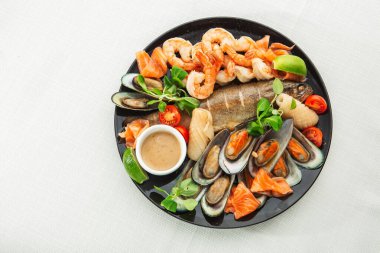 Kızarmış karışık deniz ürünleri midye, karides, somon, kalamar mürekkep balığı ve baharatlı acılı balık sarımsağı. Beyaz Arka plan 'da izole edilmiş. Deniz ürünleri ve et tabağı. Akdeniz c