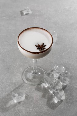 Bir bardak İrlanda kremalı likör, anason, kakao ve gri arka planda buz. Seçici odaklanma. Genel görünüm, kopyalama alanı. Kafe reklamı için. Bar menüsü. Dikey fotoğraf.