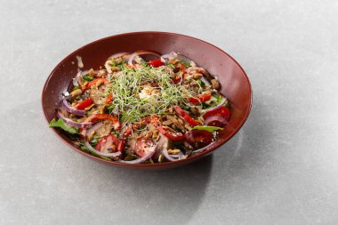 Kiraz domatesli dana salatası, siyah arka planda siyah tabakta mantar. Beyaz arka planda plaka, kopyalama alanı. Restoran yemekleri, kapatın. Et salatası. Yatay fotoğraf.