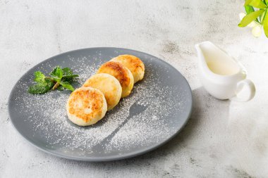 Süzme peynirli krep, Syrniki veya kremalı cheesecake, bal, beyaz mermer arka planda izole edilmiş nane. Ev yapımı yemek. Lezzetli bir kahvaltı. Seçici odaklanma. Hotizontal fotoğraf.