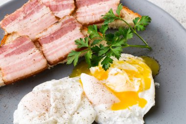 Pastırmalı haşlanmış yumurta ve ekşi ekmek. Beyaz mermer arka planda izole edilmiş. Ev yapımı yemek. Lezzetli bir kahvaltı. Seçici odaklanma. Hotizontal fotoğraf.