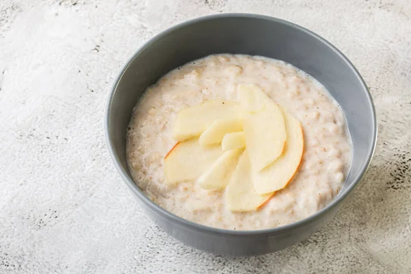 Avena gachas o gachas de avena o cereales de desayuno con manzana aislada sobre fondo de mármol blanco. Comida casera. Sabroso desayuno. Enfoque selectivo. Foto hotizontal . — Foto de Stock