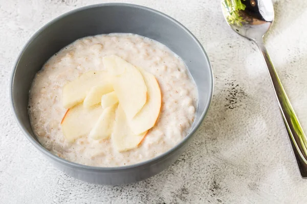 Avena gachas o gachas de avena o cereales de desayuno con manzana aislada sobre fondo de mármol blanco. Comida casera. Sabroso desayuno. Enfoque selectivo. Foto hotizontal . — Foto de Stock