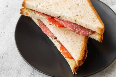 Izgara ve ezilmiş tost, füme jambon, peynir, beyaz mermer arka planda izole edilmiş. Ev yapımı yemek. Lezzetli bir kahvaltı. Seçici odaklanma. Hotizontal fotoğraf.