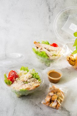 Tavuk salatası. Tavuk Sezar Salatası. Sezar salatası ve ızgara tavuk. Izgara tavuk göğsü, domates, plastik tabakta taze salata. Beyaz mermer arka planda izole edilmiş. Ev yapımı yemek. Teşekkürler.