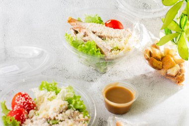 Tavuk salatası. Tavuk Sezar Salatası. Sezar salatası ve ızgara tavuk. Izgara tavuk göğsü, domates, plastik tabakta taze salata. Beyaz mermer arka planda izole edilmiş. Ev yapımı yemek. Teşekkürler.