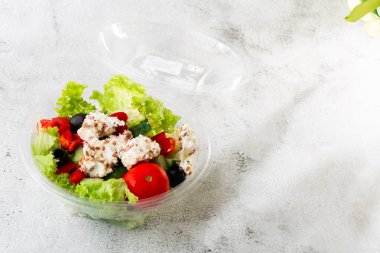 Taze salatalık, domates, tatlı biber, marul, kırmızı soğan, beyaz mermer zemin üzerinde zeytinyağı ve zeytinyağından oluşan Yunan salatası. Ev yapımı yemek. Lezzetli bir kahvaltı. Seçici odaklanma. Sıcak
