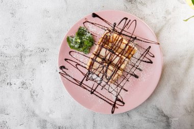 Beyaz mermer arka planda izole edilmiş çikolata soslu krepler. Ev yapımı yemek. Lezzetli bir kahvaltı. Seçici odaklanma. Hotizontal fotoğraf.