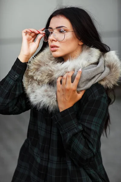 Outdoor close up fashion portrait of young beautiful confident woman wearing trendy shirt, white scarf and sunglasses Beautiful woman in luxury fur shawl. Advertising for sunglasses shop. Copy space.