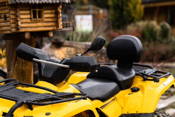 Onderaanzicht van het moderne gele terreinvoertuig op bewolkte dag. Quad fiets in stofwolk, zandgroeve op de achtergrond. Race in het zand op een vierwielaandrijving quad. — Stockfoto