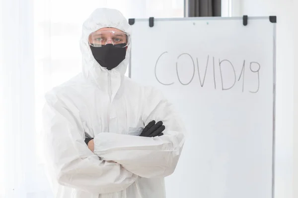 Man in protective suit, medical mask, goggles. Isolated in studio. antigas mask with glasses at white background. Man scientist in safety suit, safety virus infection concept