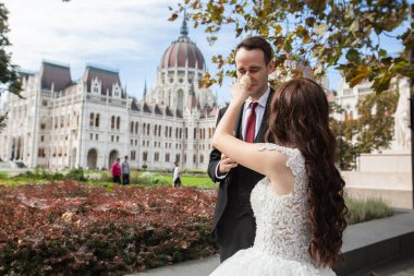 Gelin ve damat eğleniyor ve dondurma yiyorlar. Düğün çifti Budapeşte 'de Parlamento Binası yakınlarında oturuyor. Kafkasyalı mutlu romantik çift evliliklerini kutluyor. Düğün ve aşk konsepti.