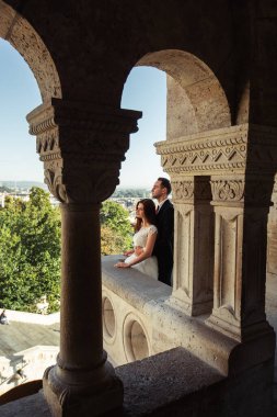 Gelin ve damat eski kasaba caddesinde sarılıyor. Budapeşte, Macaristan 'da Balıkçı Kalesi' nde yürüyen düğün çifti. Evliliklerini kutlayan mutlu romantik genç çift. Düğün ve aşk konsepti.