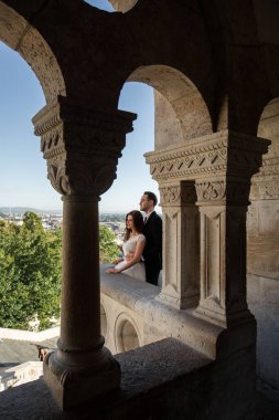 Gelin ve damat eski kasaba caddesinde sarılıyor. Budapeşte, Macaristan 'da Balıkçı Kalesi' nde yürüyen düğün çifti. Evliliklerini kutlayan mutlu romantik genç çift. Düğün ve aşk konsepti.