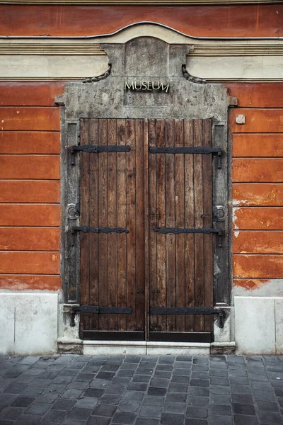 Παλιά ξύλινη πύλη ενός μουσείου με κείμενο από πάνω, κόκκινα τούβλα. Κάθετη — Φωτογραφία Αρχείου